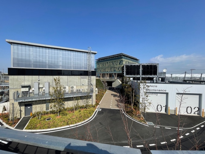 敷地内の見学者回廊上、南側から撮影。手前右に立つのが自動車・施工機械整備棟、左が道路床版のラボで奥が管理研究棟(写真:日経クロステック)