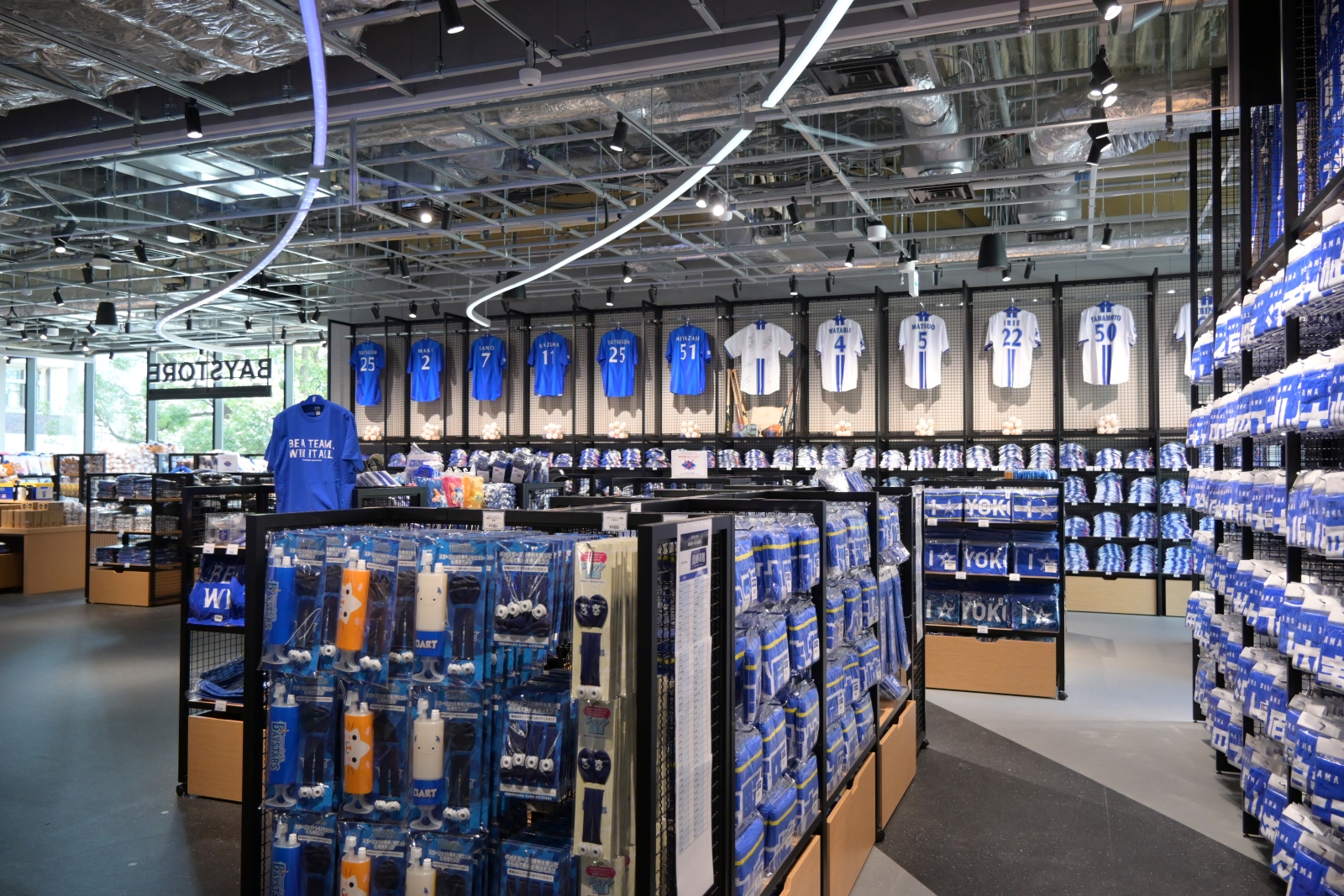 2階にあるスタンド席の背後には、横浜DeNAベイスターズのオフィシャルグッズショップを設けた（写真：日経クロステック）