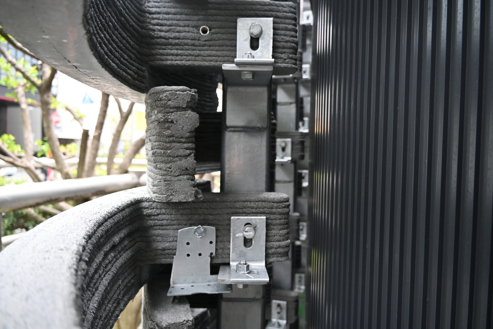 建物の外壁と外装材の間。外装材は鉄骨柱にボルト締めで固定した（写真：日経クロステック）