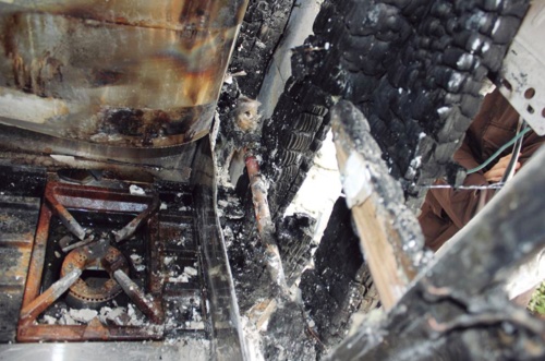 調理室の壁の焼損状態。壁内の木ずり壁や間柱が炭化して燃え抜けていた（写真：熊本市消防局）