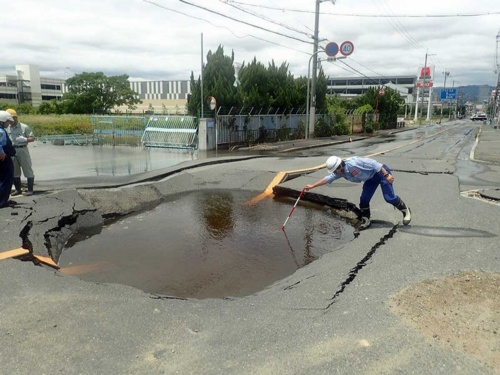 水道管の破裂によって道路にできた巨大な陥没穴(写真:国土交通省近畿地方整備局)