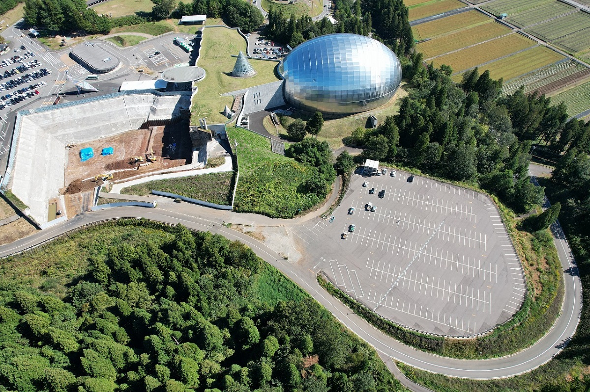 福井県勝山市にある、かつやま恐竜の森（長尾山総合公園）を西側上空から見下ろす。写真手前の第3駐車場に恐竜学部（仮称）の学部棟を新設する（資料：福井県）