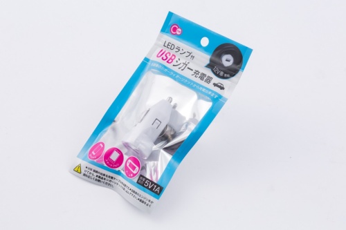 セリアで購入した「LEDランプ付USBシガー充電器」。セリアだけでなくキャンドゥなどほかの店舗でも売られていた。価格は100円（税別）。出力は電圧が5ボルトで電流は1アンペア