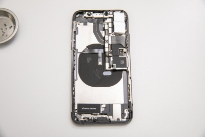 iPhone XSの本体筐体（背面側）。電磁波対策シートを貼りつけたコイルがある