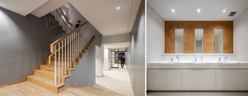 階段手すりの笠木は、CLTパネルの端材を用いた。また２～４階トイレでは写真正面に見えるように、壁面仕上げに木粉を混ぜた塗料を用いた（写真：清水建設）