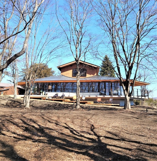 書店棟は中央部から四方に広がる大屋根が特徴だ。建物はスカートをはいた人のような断面形状をしている。CCCの本屋「軽井沢書店 中軽井沢店」とカフェ「SHOZO COFFEE STORE」、コワーキングスペースから成る(写真:日経クロステック)