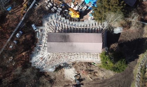 施工中の書店棟を上空から見た様子。中央に木造の既存躯体を残し、その周りに四方に手足を伸ばすかのように大屋根を架けた。真上から見ると、動物の皮を丸ごと剥いでつくる敷物のような平面をしている(写真:Klein Dytham architecture)