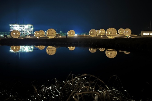 カモ池越しの夜景。左奥はアスレチックタワー「シー・ドラグーン」（写真：日経クロステック）