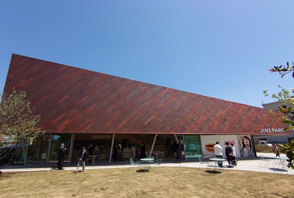 芝生の屋外広場「ひろば」から見た建物。見る角度によって異なる形に思える（写真：日経クロステック）