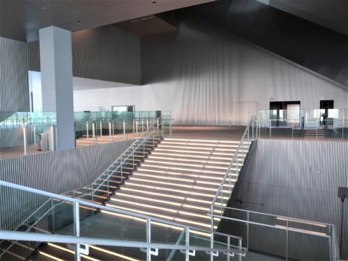 上ってきた階段を見下ろす。奥の通路が2階のパッサージュ。館内のパッサージュは2階を中心に上下につながり、巨大な空間を生み出している。2階のパッサージュを右に進むと、外の芝生広場に出られる(写真:日経クロステック)