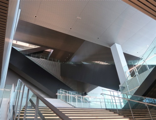 階段の途中から館内を見上げると、複雑に入り組んだ壁や柱、そして真っ黒なエスカレーターが目に飛び込んでくる(写真:日経クロステック)