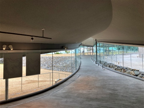 屋外のエントランス広場(右手)と屋内の回廊の高さを合わせて、屋内外を一体的に見せている(写真:日経クロステック)