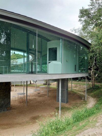 隣接する老舗の「れいがん茶屋」側から見た回廊。内部にカフェが見える。左に見えるのは地上と回廊を結ぶエレベーターで、耐震壁にもなっている(写真:日経クロステック)