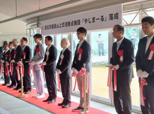 オープン前日に開かれた落成式には、高松市長など関係者が集結した。左から5番目でシルバーのスーツを着ているのが、施設の設計者の1人であるSUOの周防貴之主宰(写真:日経クロステック)