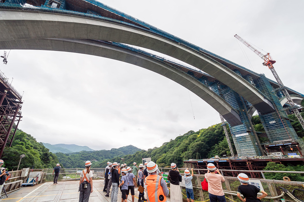 新東名「山北天空大橋」のアーチ閉合、巨大昇降装置から見上げる