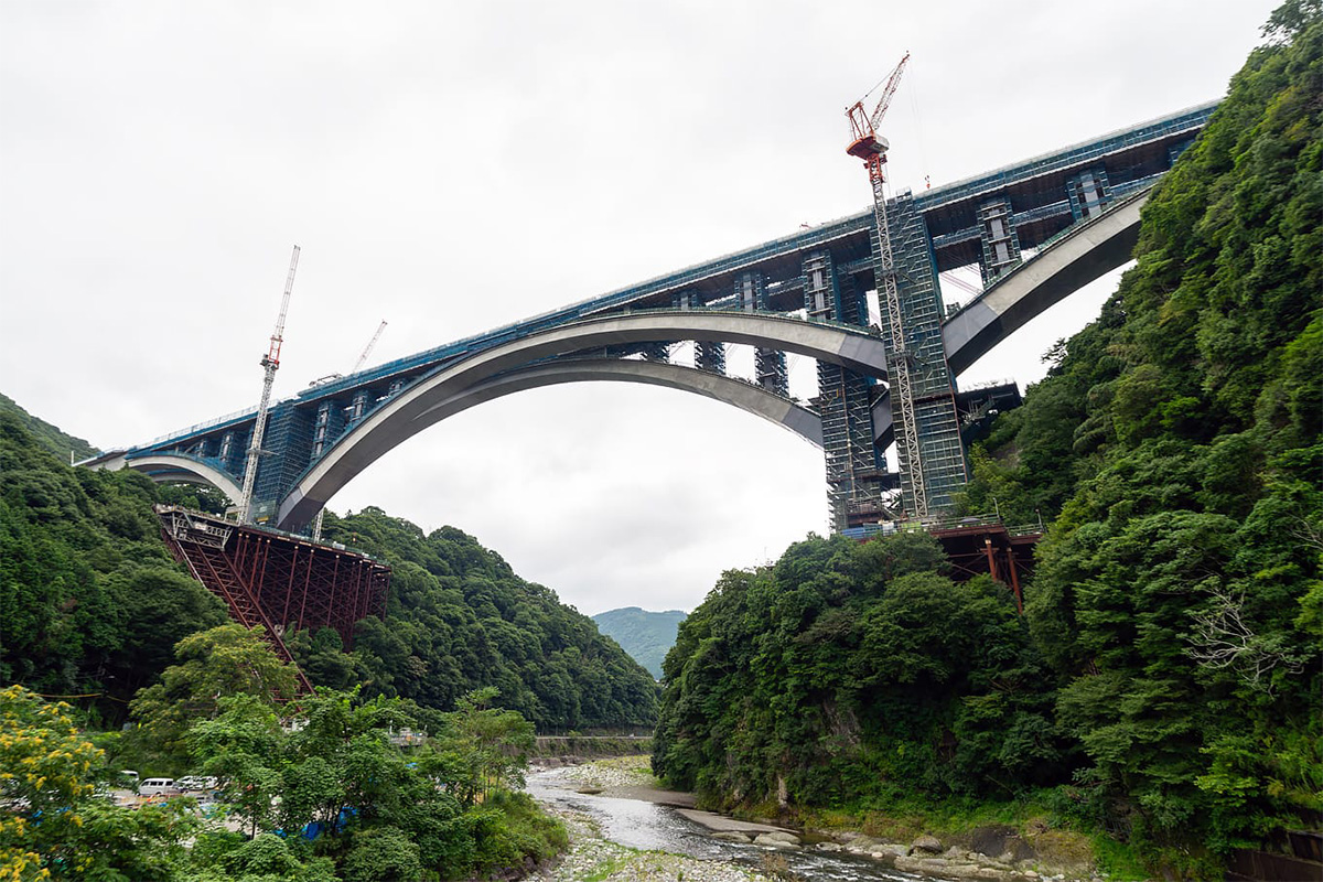 新東名「山北天空大橋」のアーチ閉合、巨大昇降装置から見上げる
