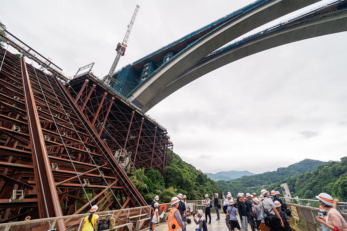 新東名「山北天空大橋」のアーチ閉合、巨大昇降装置から見上げる