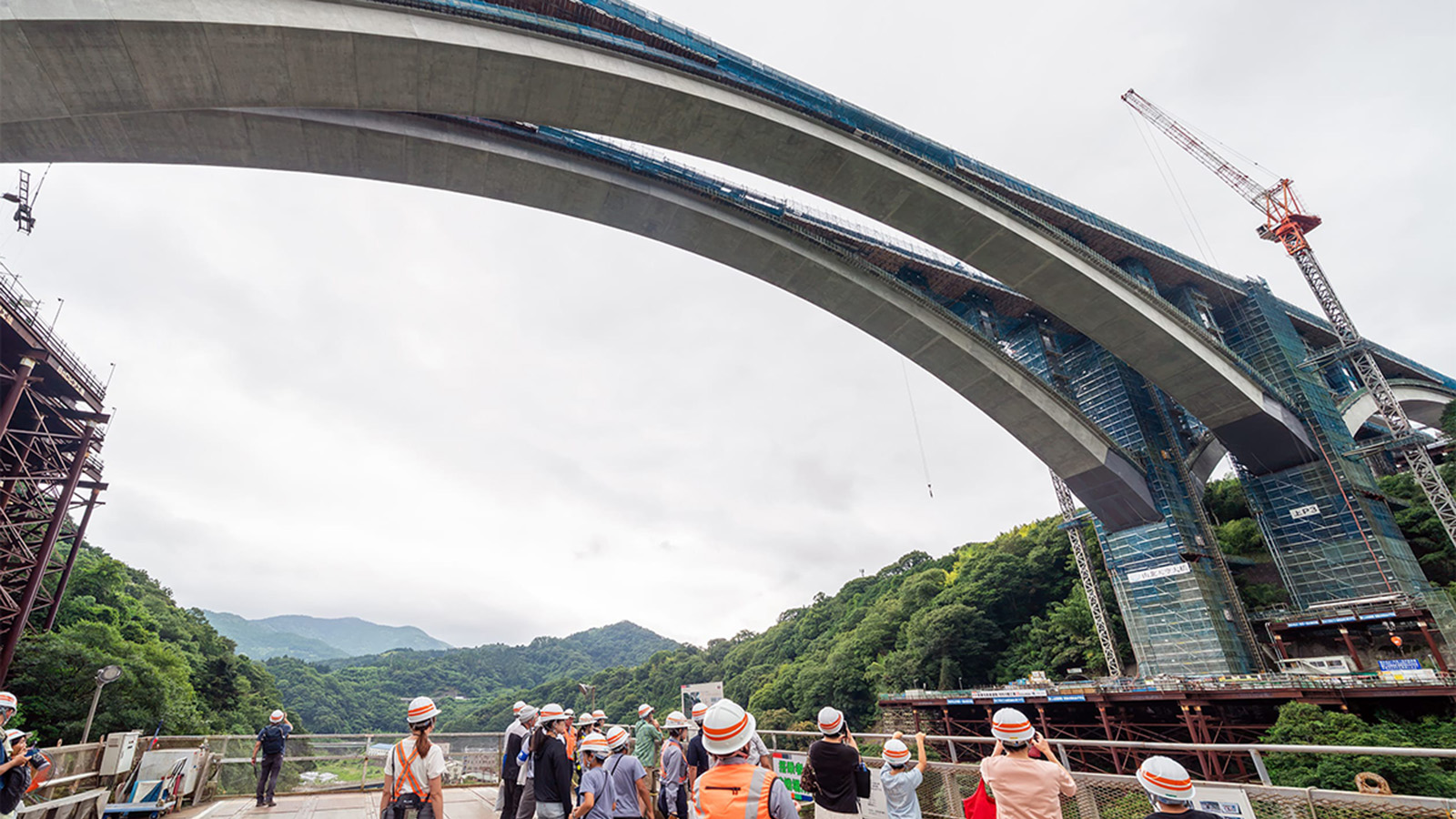 新東名「山北天空大橋」のアーチ閉合、巨大昇降装置から見上げる