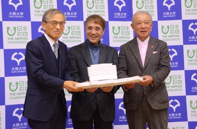 2021年12月16日の記者会見。左から、大阪大学の西尾章治郎総長、建築家の安藤忠雄氏、日本財団の笹川陽平会長。3人が持っているのが、阪大に新設する感染症研究棟の模型（写真：日本財団）