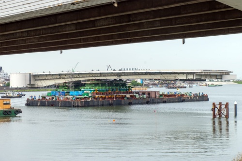 台船に載せた橋桁を運搬している様子。写真上部に見える橋桁は損傷が進む既設橋。2022年5月14日に撮影（写真：大上 祐史）