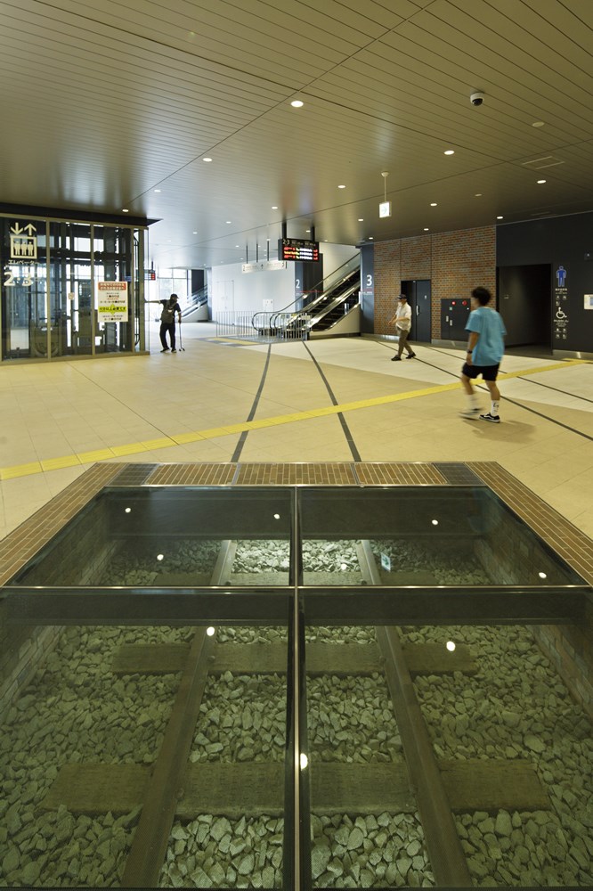 駅構内の床下に設置したレールモニュメント。床面には筑豊本線と鹿児島本線が交差するレール跡を表示した（写真：イクマ サトシ）