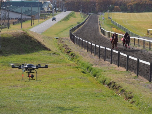 8Kカメラを搭載したドローンを活用した5Gの伝送も実施。軽種馬のトレーニングの様子を上空から撮影、確認できるという。写真は2019年11月13日の「8Kライブ映像を活用した軽種馬育成支援の実証試験」より（筆者撮影）
