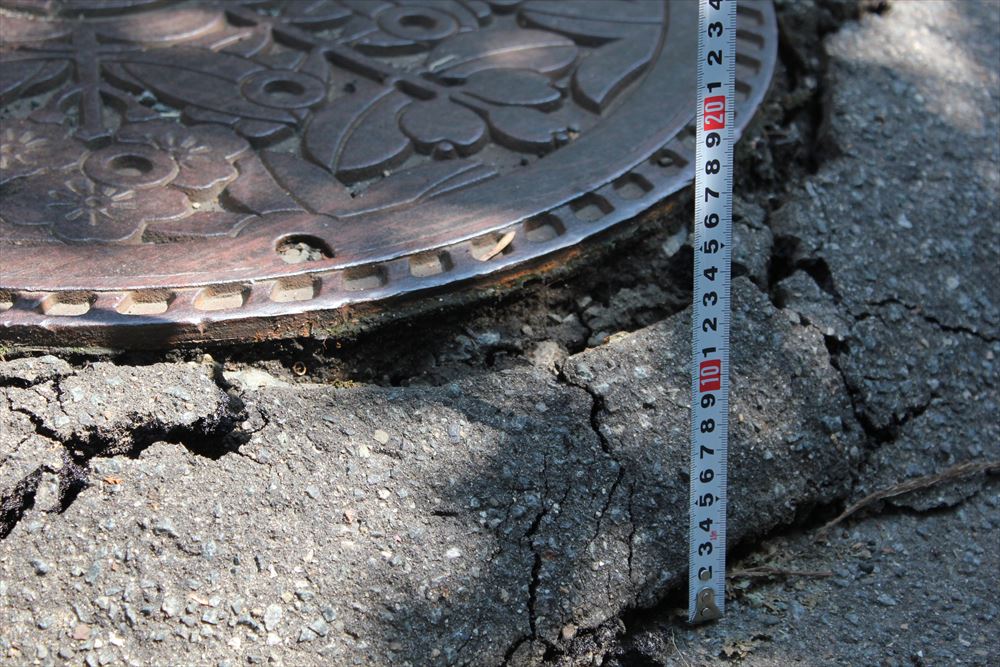路面が下がったためマンホールが浮き上がったように見える。2019年6月20日に撮影（写真：日経 xTECH）