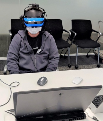 「高臨場感可聴化システム」を体験しているところ。動作検知センサーも付いており、顔の向きを変えるとVR空間内で見える景色や音の聞こえ方が変わる(写真:日経クロステック)