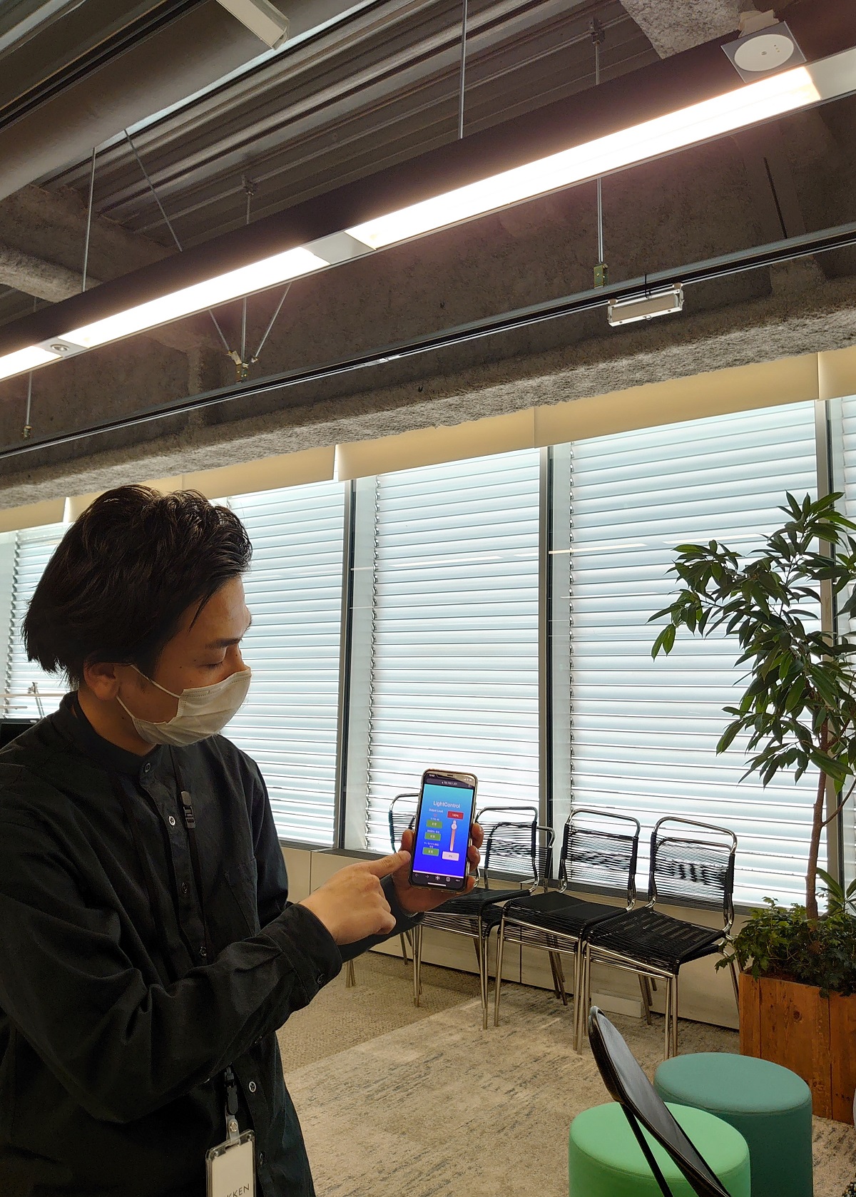 事前に登録した社員であると認証されると、自分のスマートフォンアプリから照明の明るさを自由に調整できるようになる（写真：日経クロステック）