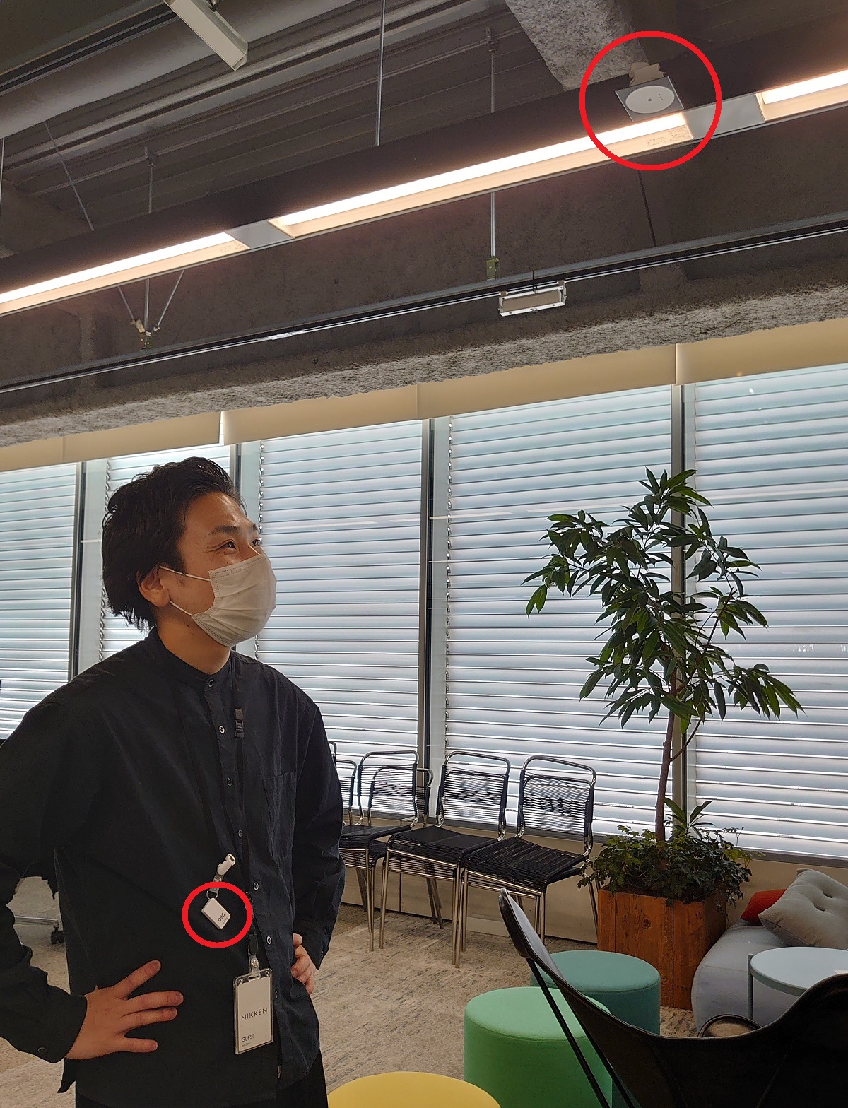 大浦氏がビーコン（小さな赤い丸印）を身に着け、Bluetoothに対応した照明のセンサー（大きな赤い丸印）が個人を特定する（写真：日経クロステック）