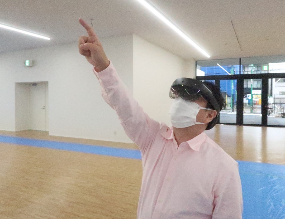 HoloLens 2をかぶった私。検査担当者のまねをして、垂れ壁を指さす（写真：日経クロステック）