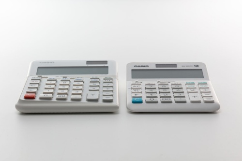 写真左はDE-12D-WEで、写真右は一般的な電卓。DE-12D-WEはキーのある操作面が3度傾いている