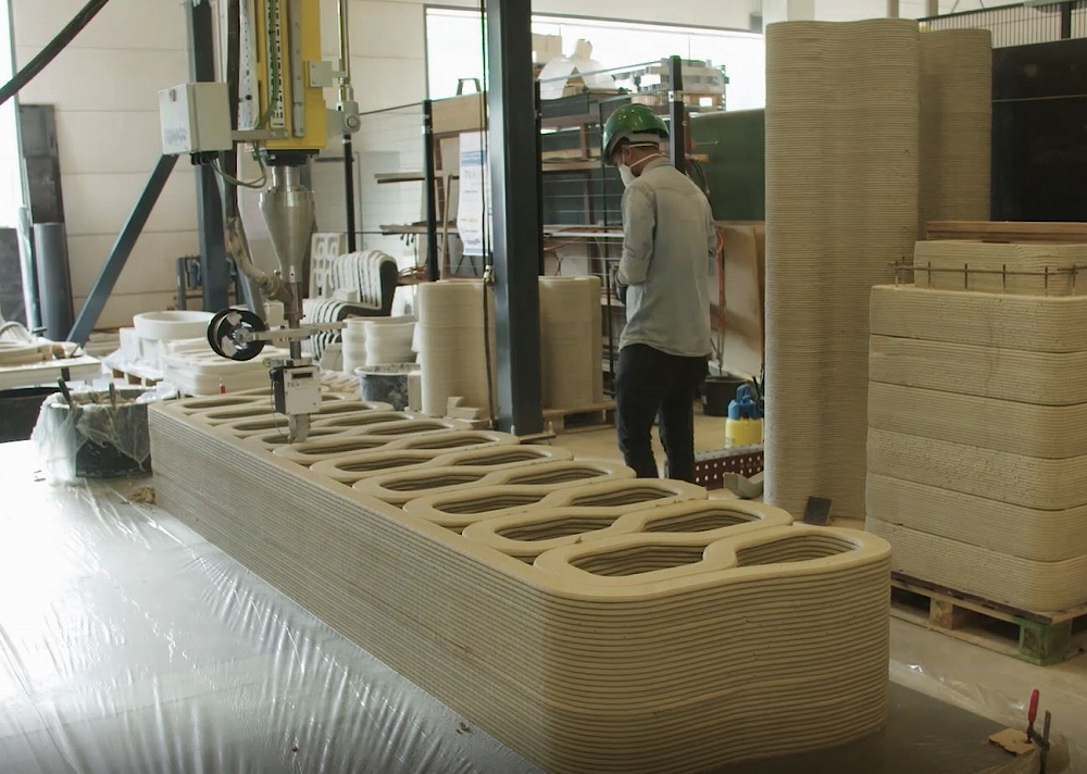 アイントホーフェン工科大学のコンクリート3Dプリンターでモルタルを積層し、橋桁の部材を築く様子。上に見えているのが桁の断面。設計の自由度が高い3Dプリンターの強みを生かし、中空断面を採用した（写真：BAM Infra）