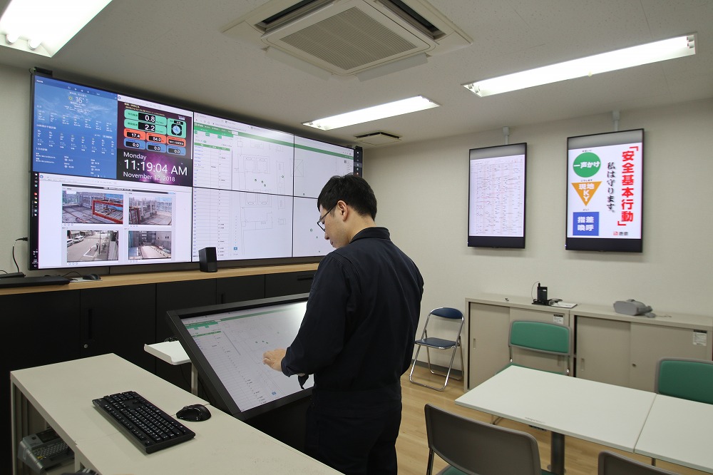 名古屋伏見Kスクエアの工事事務所。気象情報や顔認証による入退場情報、モニタリングカメラの映像など遠隔管理に必要な情報を大型モニターに表示した（写真：日経アーキテクチュア）