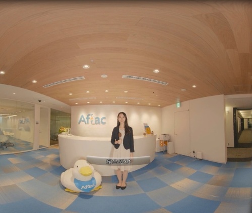 アフラック生命保険が社内研修のオフィスツアーで活用しているVRコンテンツ。ナレーター役の社員が本社の各部門を訪問して様子などを紹介していく。360度見渡せる映像になっている