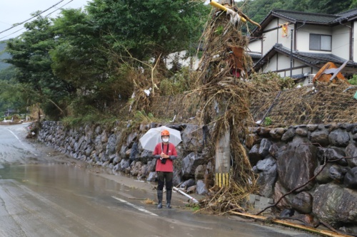 串刺し状の建物から県道を挟んだ隣の電柱。上部にまで草が絡みついている。熊本大学くまもと水循環・減災研究教育センターが7月12日に実施した調査によると、坂本での浸水位は地上5.4mに達した模様(写真:水源地環境センター)