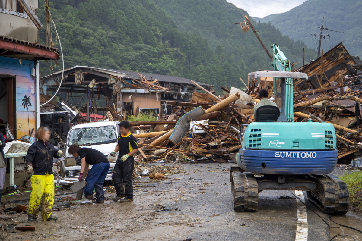 渡の集落内を相良橋に向かう道路。前方が下流側。流木の作用も加わり破壊されたとみられる家屋が道路を塞いでいた。7月10日撮影（写真：水源地環境センター）