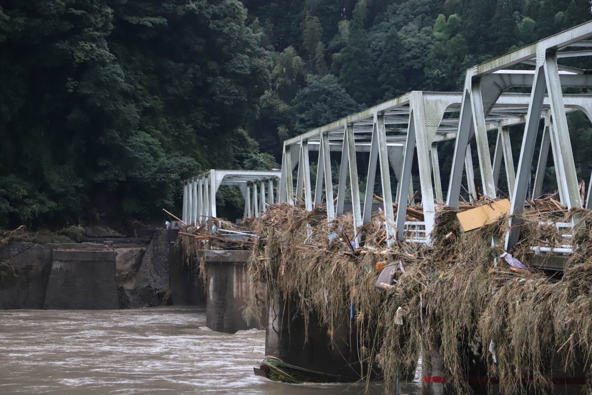 人吉市内の西瀬橋を右岸側の上流寄りから眺めたところ。写真奥から2番目の橋桁が流失し、橋には多くの流木や草が絡みついている（写真：水源地環境センター）