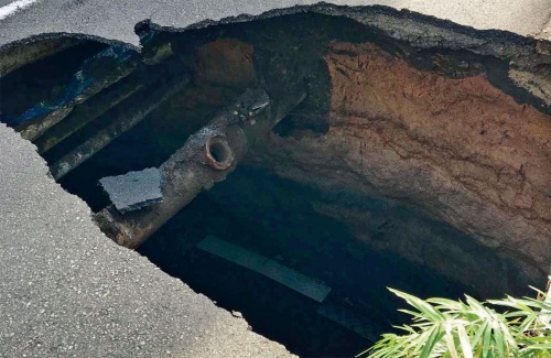陥没した穴。直径25cmの下水道管が見える（写真：東日本高速道路会社）