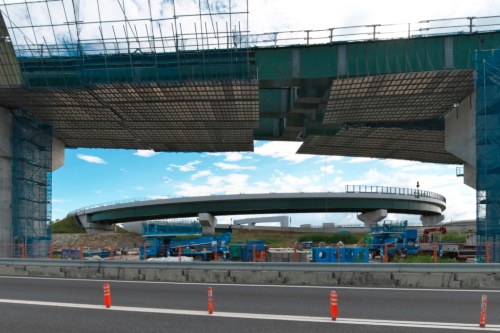 建設中の高架橋の向こうにはすでに開通済みの新名神高速道から京奈和自動車道へと合流するランプが見える（写真：生田 将人）