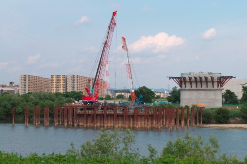 高槻市側から見た枚方市側の淀川河川敷の様子。淀川の中には橋脚建設のため矢板が打ち込まれ、基礎工事が進められている(写真:生田 将人)