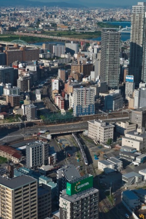 梅田スカイビルの展望台からうめきた2期の北側を見下ろす。地下化工事が進められているJR東海道線支線を走る電車が見える（写真：生田 将人）