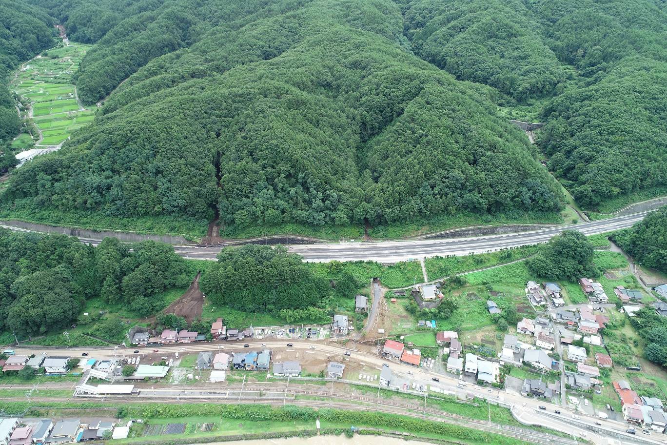 長野県岡谷市で発生した土石流。写真左部では、土砂が中央自動車道の下を通り抜け住宅に流れ込んだ様子を確認できる（写真：長野県建設部砂防課）