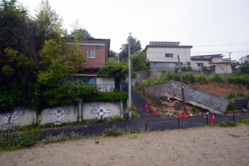 仙台市太白区緑ケ丘4丁目付近であった擁壁崩れ。隣に見えるのは2011年の東日本大震災で被災し、アンカーで対策を講じていた擁壁。今回の地震では無被害だった（写真：日経クロステック）
