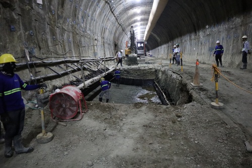 トンネル内で、インバートコンクリートを施工する様子。掘削工事と並行して作業する(写真:日経クロステック)