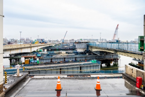 高速道路の路面上で川崎市側から見た高速大師橋の架け替え工事。写真中央に既設の橋桁が架かっていた。左手(上流側)にある既設の橋桁をスライドした後、右手にある新設の橋桁を移動する前の様子(写真:大村 拓也)