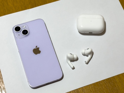 紫を意識しやすいように白い紙の上でパープルのiPhone 14を撮影した。周囲の変化で印象が変わって見える