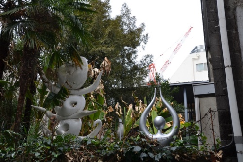 庭から塀越しに顔をのぞかせる彫刻作品。まるで生きているかのような存在感を発揮(写真:渡辺 圭彦)