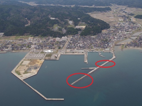 飯田港の航空写真。赤丸で囲んだのが東側防波堤の消失箇所。赤丸は日経クロステックが加筆(写真:海上保安庁第九管区海上保安本部)