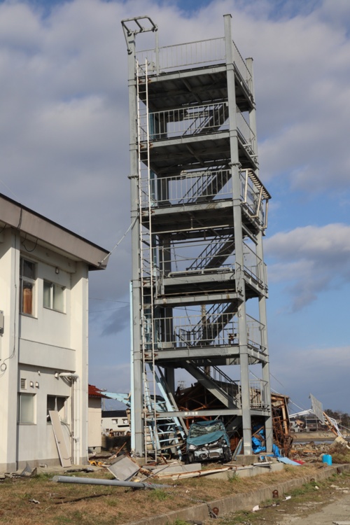 飯田港の避難タワーの下には、津波で押し流された車が見える。2024年1月5日撮影(写真:日経クロステック)